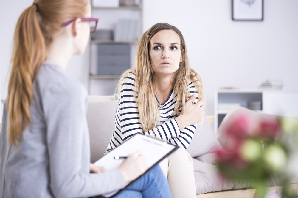 Our highly trained therapists are here to help. Sad woman with mental disorder during therapy with psychiatrist